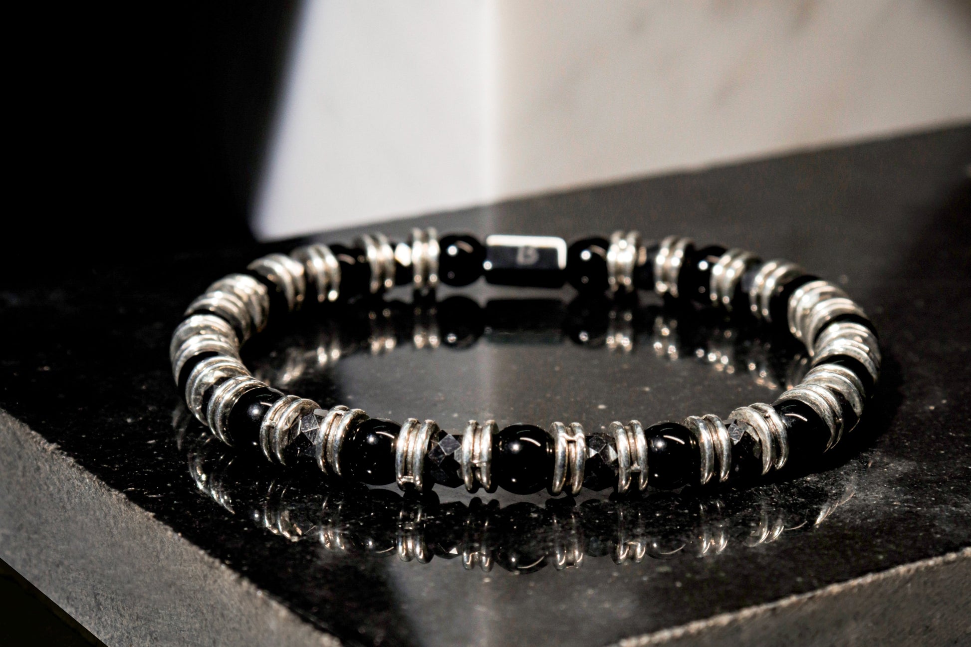 Black Onyx Bracelet by Beneka – Natural Stone Slip-On Bracelet with 6mm polished Black Onyx beads, stainless steel rings, and premium elastic silicone cord. Elegant unisex luxury wrist accessory for protection, style, and energy balance.